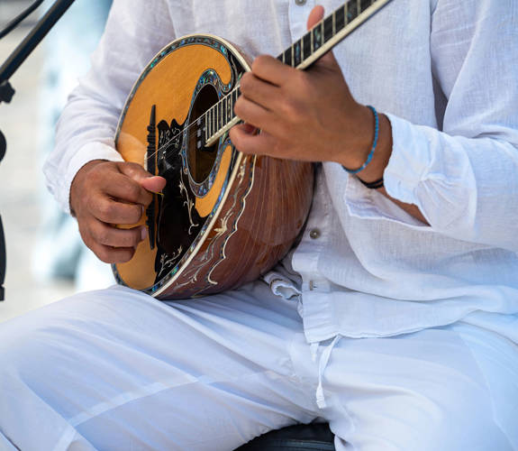 Marni Village musician playing traditional Greek music in a live outdoor performance