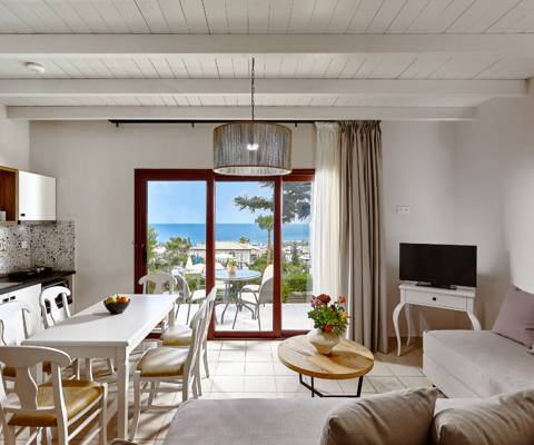 Marni Hotel Superior House Suite living and dining area with cornered sofa, dining table, TV and access to terrace