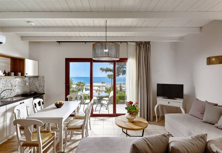 Marni Hotel Superior House Suite living and dining area with cornered sofa, dining table, TV and access to terrace