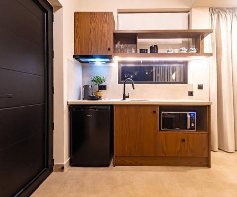 Marni Hotel Luxury Two Bedroom Villa kitchenette with modern wooden cabinets, compact fridge and microwave