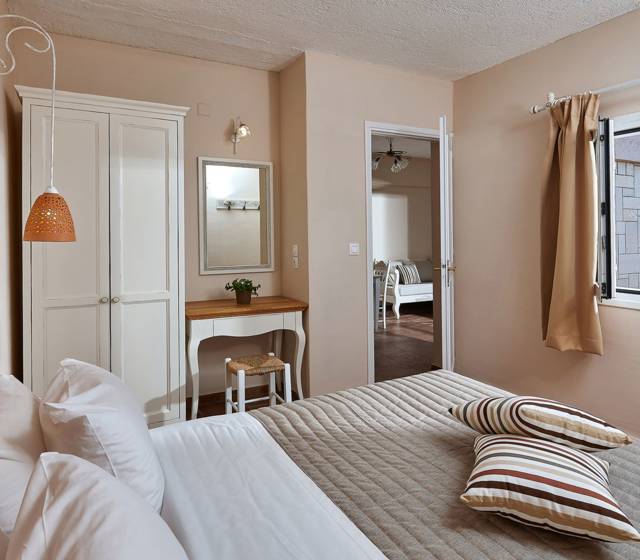 Marni Hotel Premium One Bedroom Apartment interior with double bed, window view and connecting living area