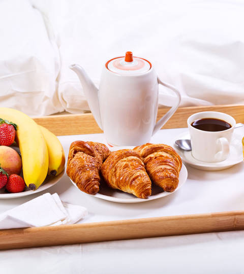 Marni Village breakfast in bed with croissants, coffee, fresh juice and fruit