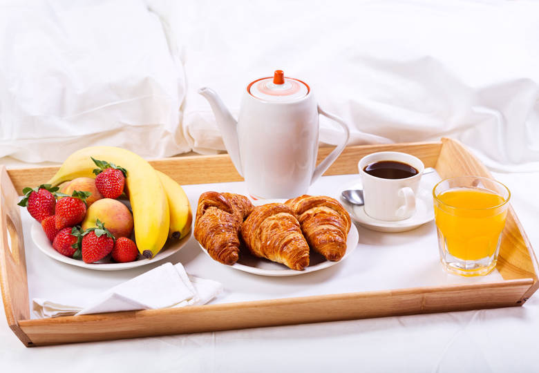 Marni Village breakfast in bed with croissants, coffee, fresh juice and fruit