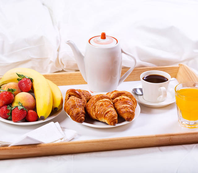 Marni Village breakfast in bed with croissants, coffee, fresh juice and fruit