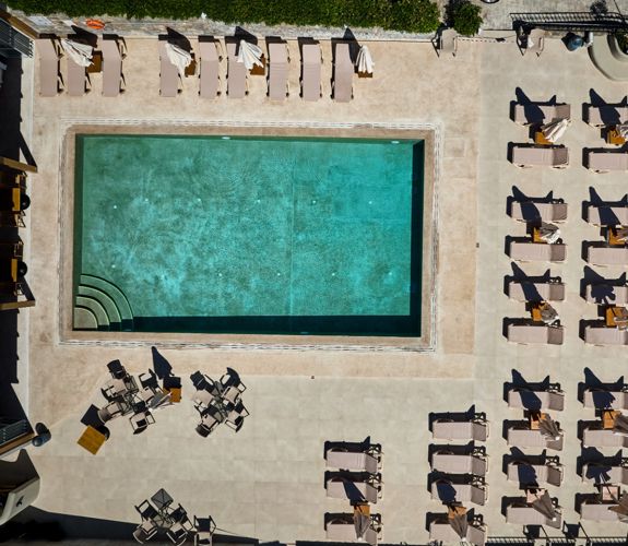 Marni Village aerial top down view of shared pool with umbrellas and sunbeds 