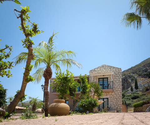 Marni Village Two-story stone villa surrounded by palm trees