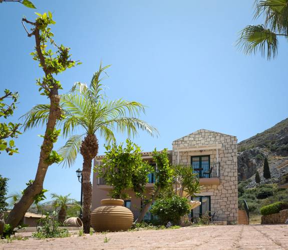 Marni Village Two-story stone villa surrounded by palm trees