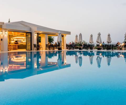 Marni Village Main pool with bar and restaurant area at sunset