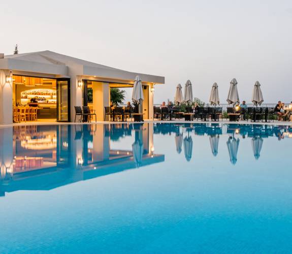 Marni Village Main pool with bar and restaurant area at sunset