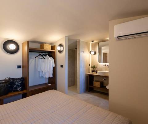 Marni Hotel Luxury One Bedroom Villa bedroom with double bed, open wardrobe and bathroom