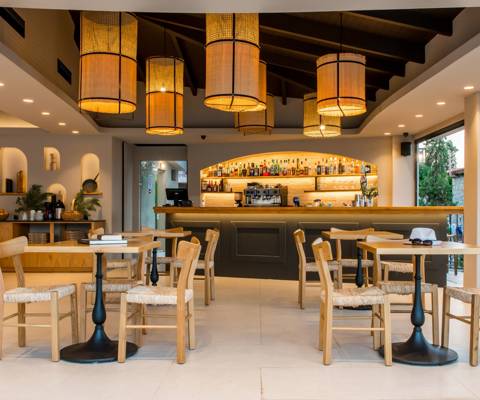 Marni Village Restaurant with wooden furniture, warm lighting and a fully stocked backlit bar