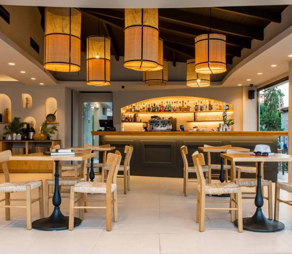 Marni Village Restaurant with wooden furniture, warm lighting and a fully stocked backlit bar
