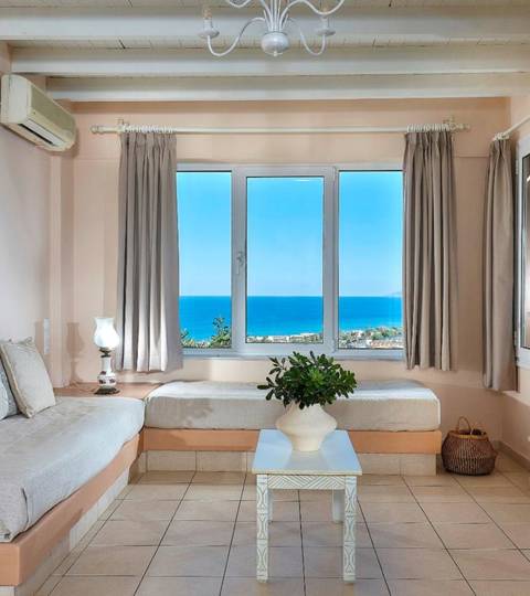 Marni Hotel Family Suite living area with sofas, fireplace and window with sea view