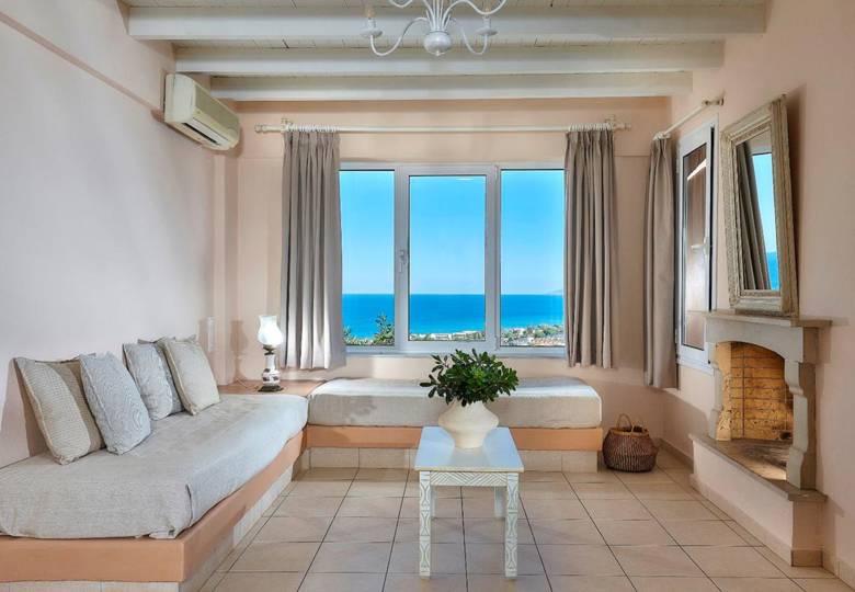 Marni Hotel Family Suite living area with sofas, fireplace and window with sea view