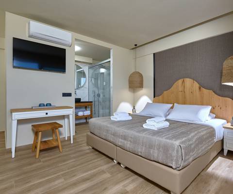 Marni Hotel Deluxe Maisonette Private Pool bedroom with double bed, wall mounted TV and modern open bathroom
