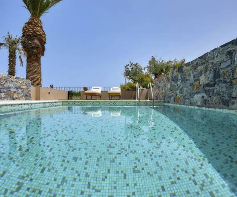 Marni Hotel Studio Private Pool outdoor area with private pool, stone walls, and sunbeds