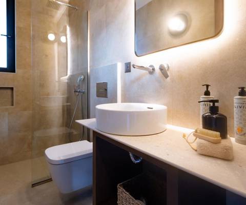 Marni Hotel Luxury Two Bedroom Villa bathroom with backlit mirror, vessel sink, wooden vanity and walk in shower