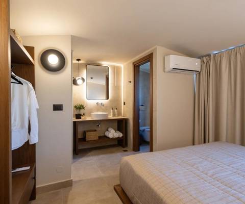 Marni Hotel Luxury One Bedroom Villa bedroom with open closet, en-suite bathroom andmodern lighting