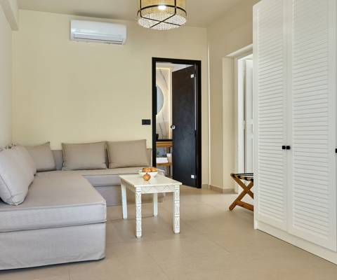 Marni Hotel One Bedroom Apartment Private Pool living area with cornered sofa, coffee table and wardrobe