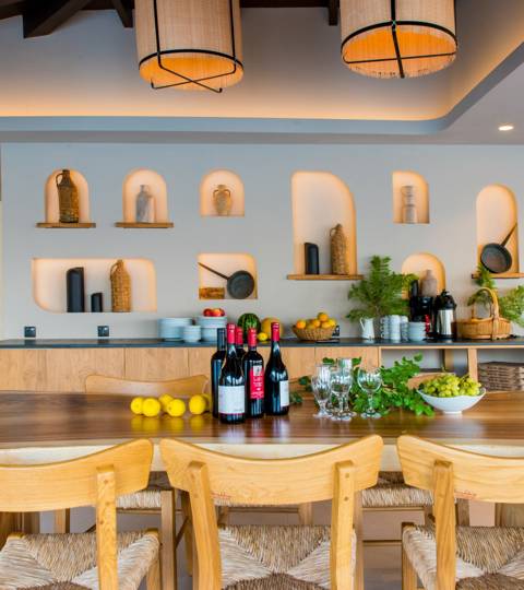 Marni Village wine and fruit display on a wooden counter with decorative wall niches