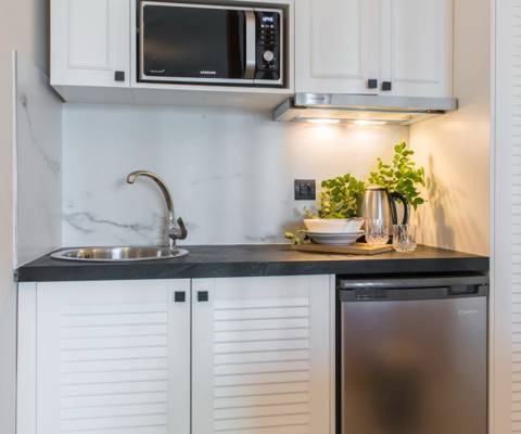 Marni Hotel Studio Private Pool kitchenette with mini fridge, microwave, and marble backsplash