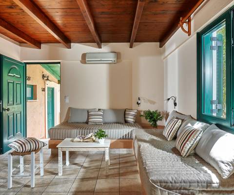 Marni Hotel Superior One Bedroom Apartment living area with built-in sofas and wooden ceiling