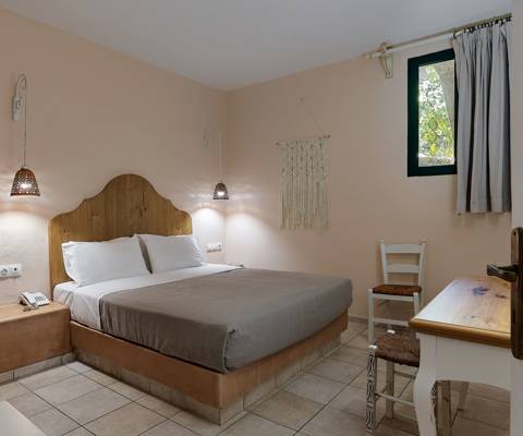 Marni Hotel Superior One Bedroom Apartment bedroom with double bed and rustic decor