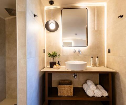 Marni Hotel Luxury Two Bedroom Villa bathroom with backlit modern mirror, vessel sink, wooden vanity and walk-in shower
