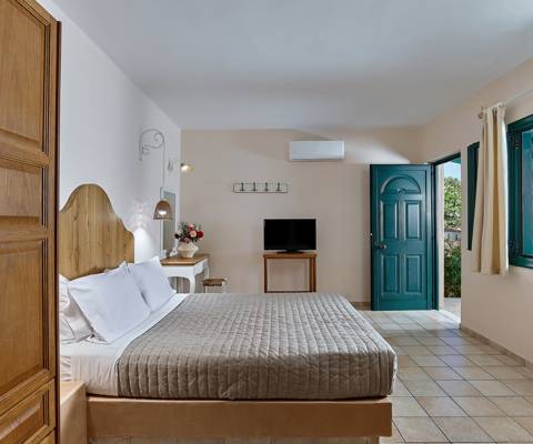 Marni Hotel Premium Studio interior with double bed, wooden wardrobe and turquoise door
