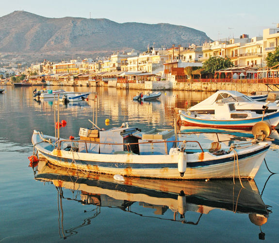 Fishing boats floating in Hersonissos harbor at sunrise