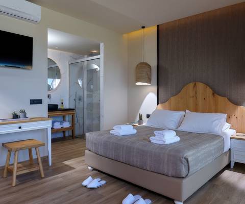 Marni Hotel Deluxe Bungalow Private Pool bedroom with double bed, wall mounted TV and modern open bathroom