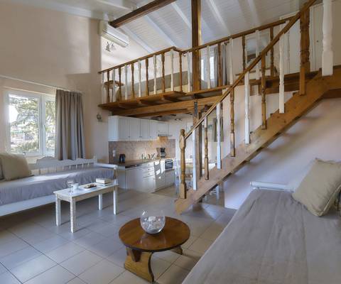 Marni Hotel Maisonette living area with sofas, coffee tables, dining area, wooden staircase and window view