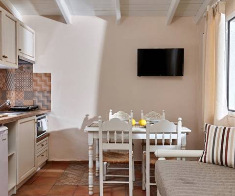 Marni Hotel Two Bedroom Apartment kitchen and dining area with sofa, TV, and vintage tiled backsplash