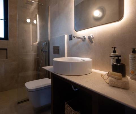 Marni Hotel Luxury One Bedroom Villa bathroom with backlit mirror, vessel sink, wooden vanity and walk in shower