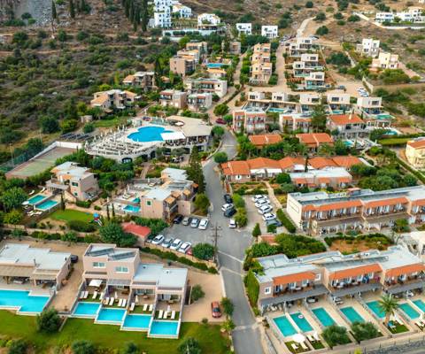 Marni Village aerial view of Hersonissos coastline and hillside suites with private and shared pools