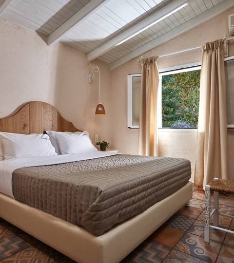 Marni Hotel Premium One Bedroom Apartment bedroom with double bed, rustic decor and window view