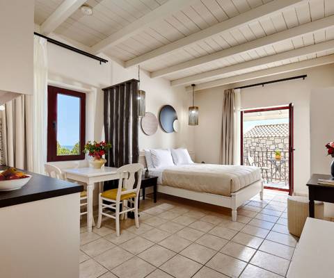 Marni Hotel Junior Suite interior with bed, kitchenette, dining table and access to private balcony
