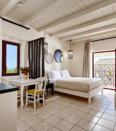 Marni Hotel Junior Suite interior with bed, kitchenette, dining table and access to private balcony