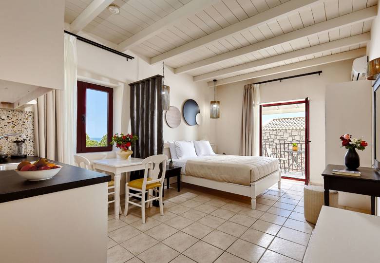 Marni Hotel Junior Suite interior with bed, kitchenette, dining table and access to private balcony