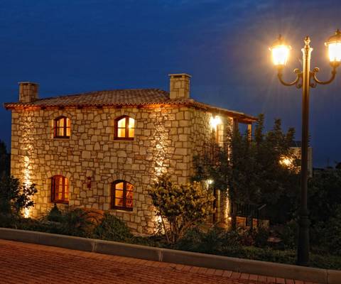 Marni Hotel House Maisonette exterior view at night with stone walls and warm lighting