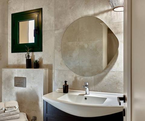 Marni Hotel Villa bathroom with round mirror, sink and modern design